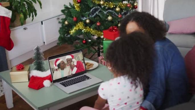 圣诞节期间，与祖父母在笔记本电脑上进行视频通话的非洲裔美国母女快乐