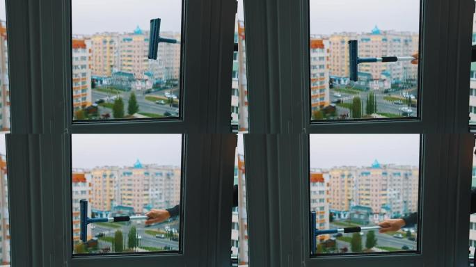 从户外清洁窗户。特殊的刷子正在清洗城市背景上的玻璃窗。清洁服务。