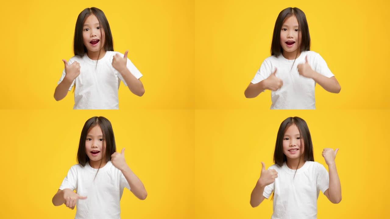亚洲小女孩在黄色背景上竖起大拇指摆姿势