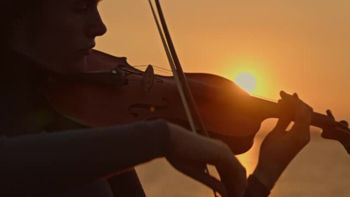 女人在日出时演奏小提琴