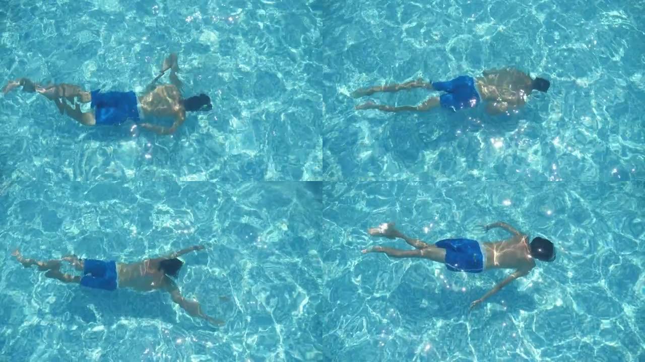 穿着短裤的黑发男人夏天在slo-mo的水下游泳池游泳