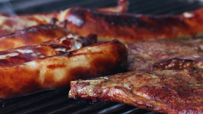 在烤架上特写5个香肠和两片肉。香肠发出嘶嘶声，可以看到淡淡的烟雾。一片肉正在转动。