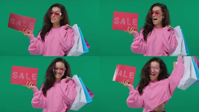 购物销售女人展示购物标志，写有销售。高加索美丽微笑的女人，带着购物袋。在绿色屏幕上，色度键