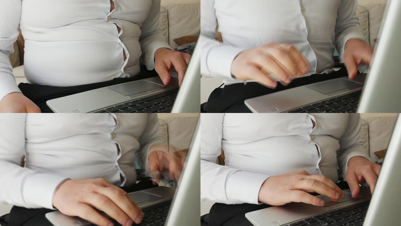 胖胖的肚子男人在家穿着紧身工作衬衫的笔记本电脑工作