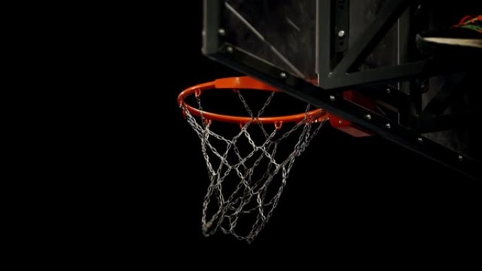 篮球场。将球扔进聚光灯背景上的篮球架中。