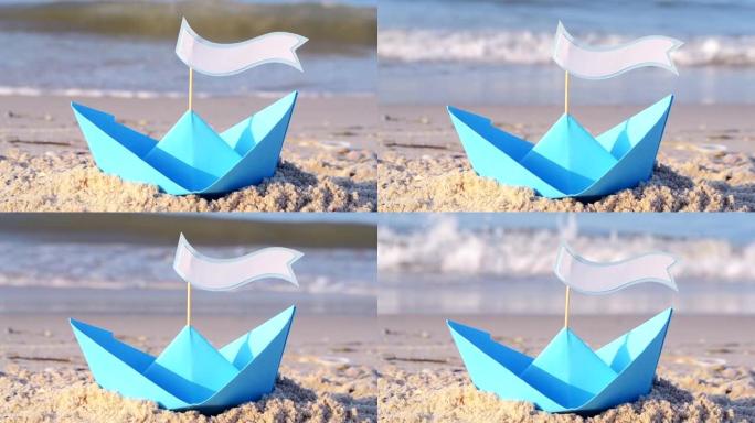 在阳光明媚的夏日，蓝纸船在海边的沙滩上。在船上，有文字空间。海浪附近沙子上的小船。概念旅行，旅游，度