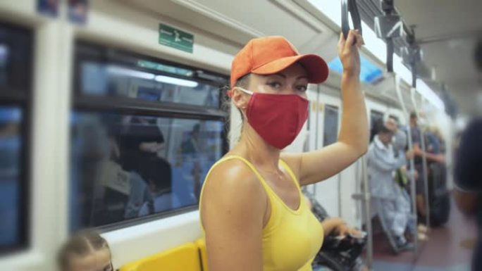 女人戴着防护医用口罩在地面火车上乘坐高加索人。带呼吸器的空中列车上的女孩游客。人们面具
