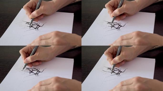 设计师使用黑色记号笔在纸上工作。艺术家在纸上画了一幅素描。手边的特写镜头，在纸上画线。神经造影和治疗