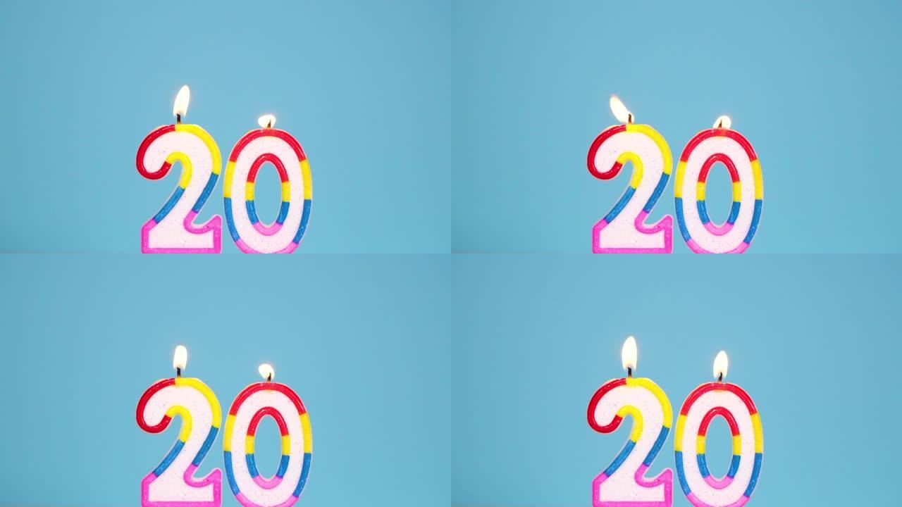 周年纪念视频横幅，燃烧着，然后在蓝色背景上吹出五颜六色的二号蜡烛。全高清慢动作分辨率周年纪念或生日横