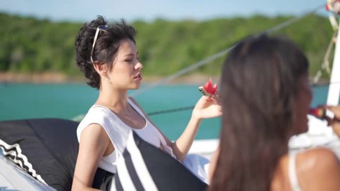 4k高加索女性朋友喜欢在暑假一起航行的双体船时吃新鲜水果