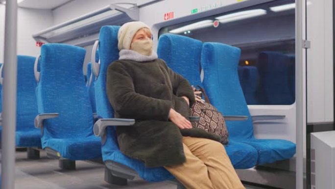 始终保持联系。戴着口罩的成熟女性在乘坐旅客列车时正在使用智能手机并检查社交媒体。
