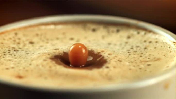 一滴泡沫掉进一杯咖啡里。拍摄的是每秒1000帧的慢动作。