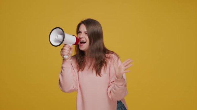 快乐的年轻女子与扬声器。情绪激动的女孩对着扩音器大声宣布销售。促销广告的概念