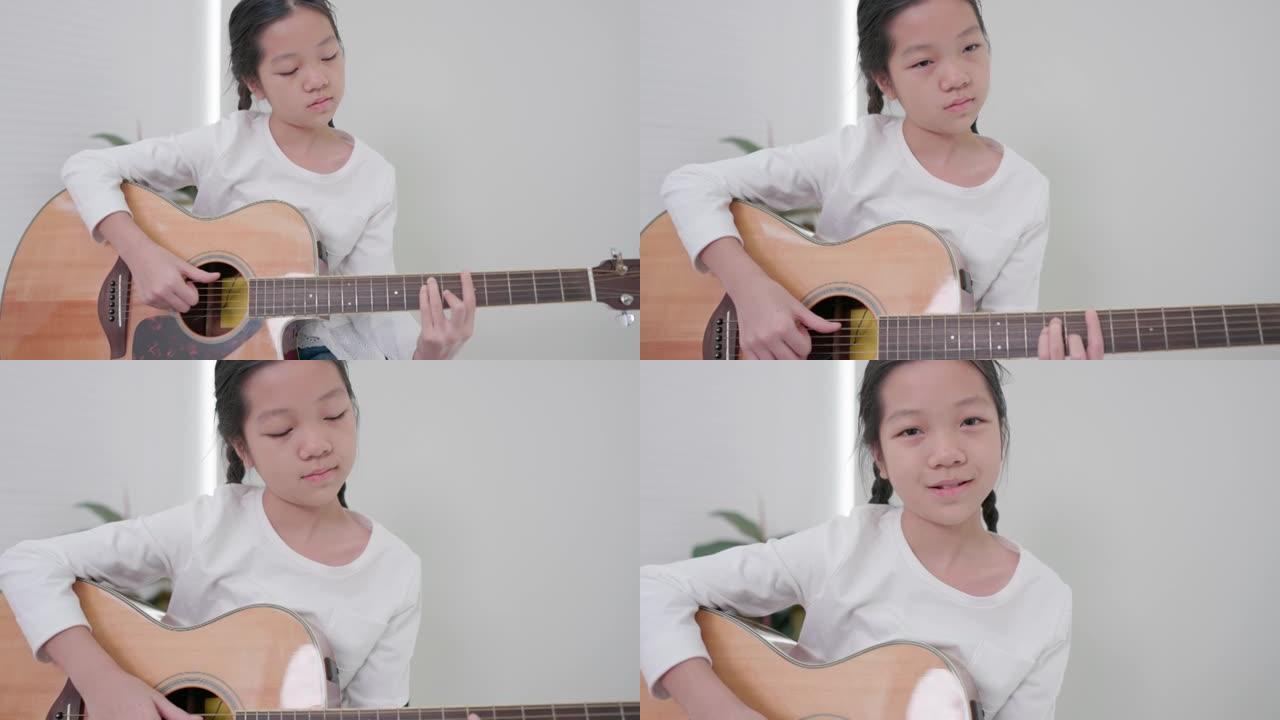 亚洲在沙发上，一个十几岁的女孩弹原声吉他，而一个小孩弹吉他。