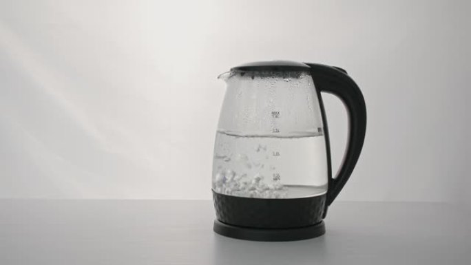 家用技术，电透明水壶加热水，由于水的高温和沸腾的背景，蒸汽滴向下流动玻璃