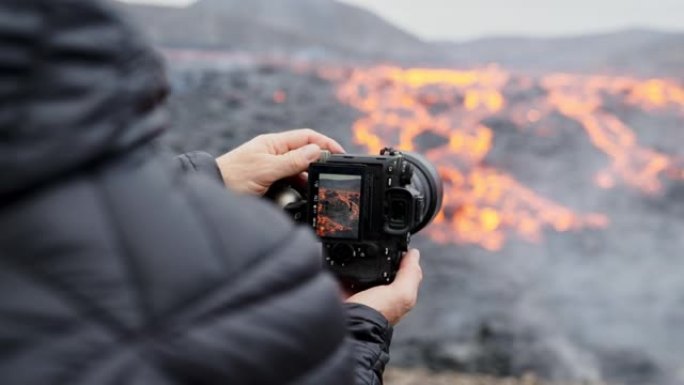 摄影师用熔岩流调整三脚架上的相机