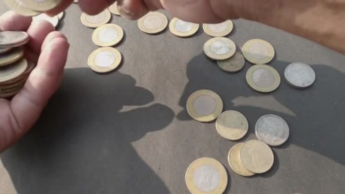 人手从地板上捡起印度卢比硬币。特写。高角度视图。商业金融行业背景。