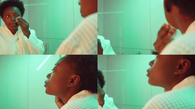 非裔美国妇女在浴室使用爽肤水