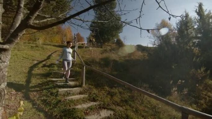 自信的年轻夫妇在秋天从楼梯上慢跑。侧视图拍摄。相机中的太阳反射 ..复制空间