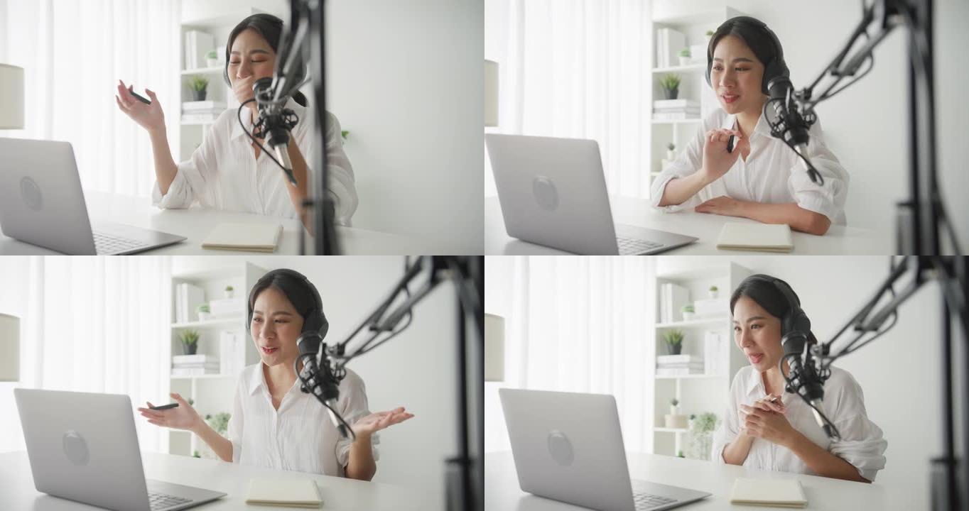 年轻的亚洲女性在家庭工作室的笔记本电脑上录制播客。