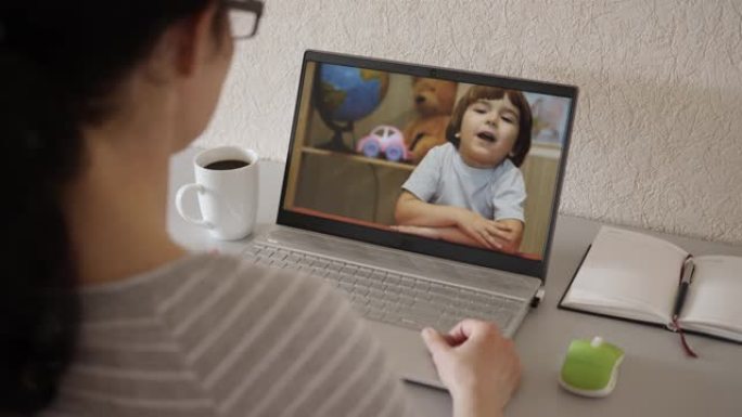 远程教育。通过笔记本电脑与妈妈通话的小孩视频通话。在线导师，母亲，儿科医生与儿童视频通话使用计算机。
