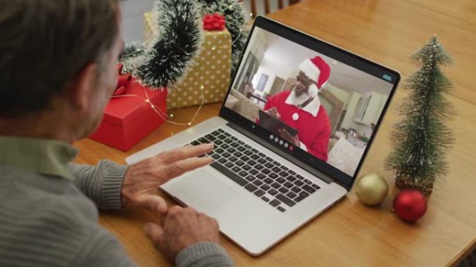 快乐的高加索高级男子在圣诞节与圣诞老人进行视频通话