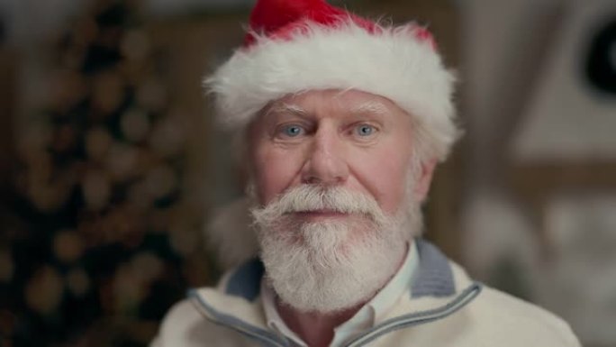 戴着圣诞老人帽子的老人。他笑了。留着灰色胡须和小胡子的人。新年假期。