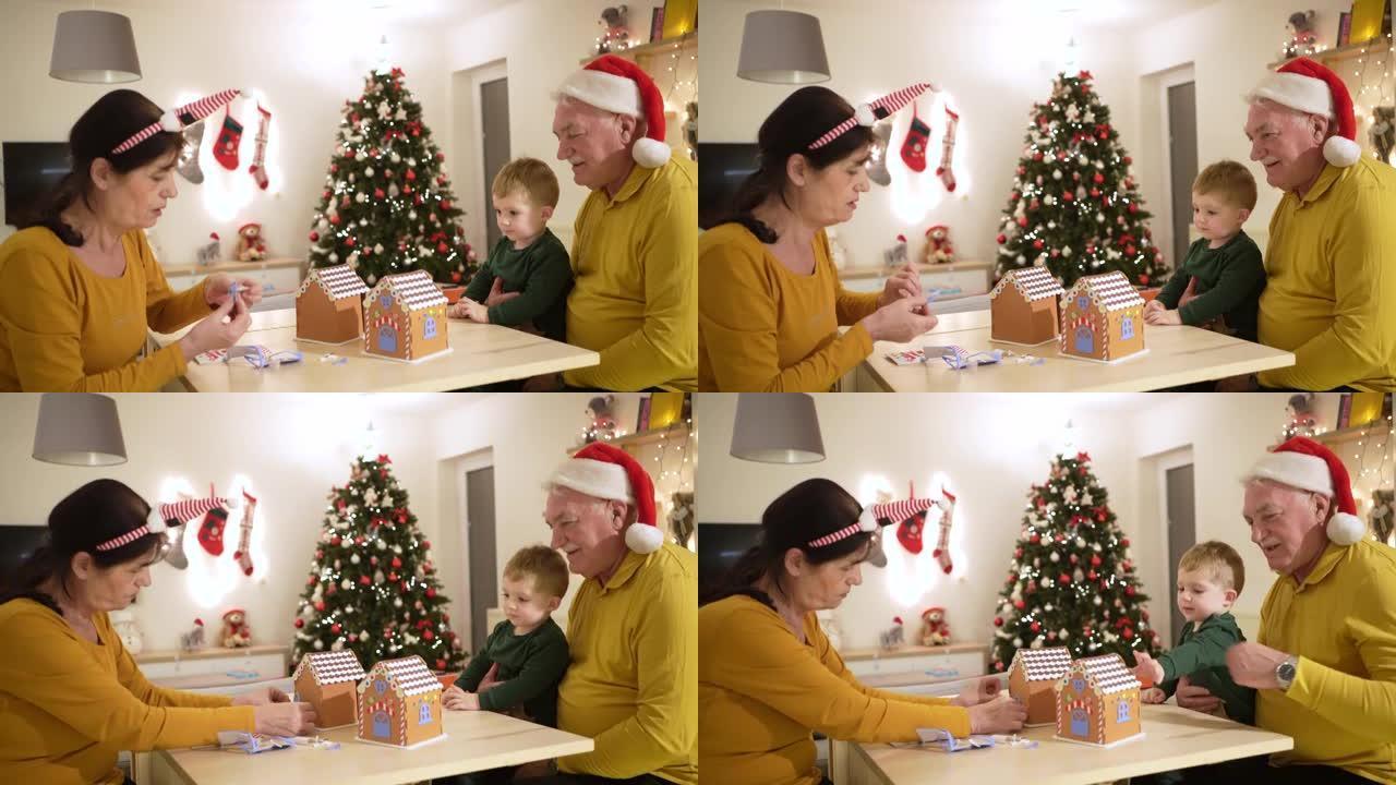 作为圣诞节的传统，快乐的高加索祖父母和孙子一起装饰姜饼屋