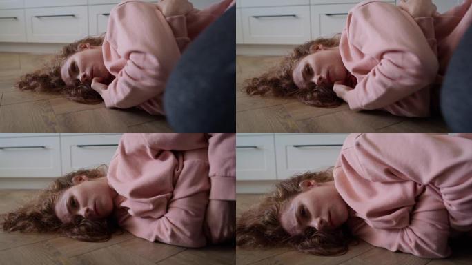 放大沮丧的年轻白人妇女躺在地板上的视频。用8k的红氦相机拍摄