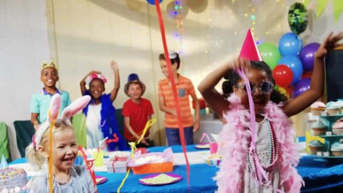 五彩纸屑的动画落在生日聚会上跳舞的不同孩子身上