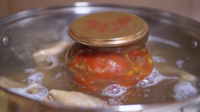 在沸水锅中对一罐腌制的西红柿进行灭菌的过程