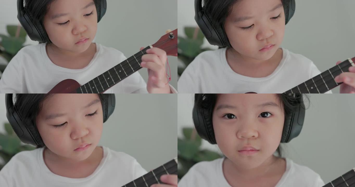 亚洲在沙发上，一个十几岁的女孩弹原声吉他，而一个小孩弹吉他。