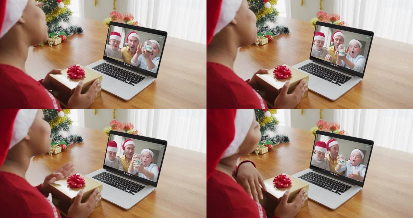 戴着圣诞老人帽子的非洲裔美国妇女使用笔记本电脑与家人在屏幕上进行圣诞节视频通话