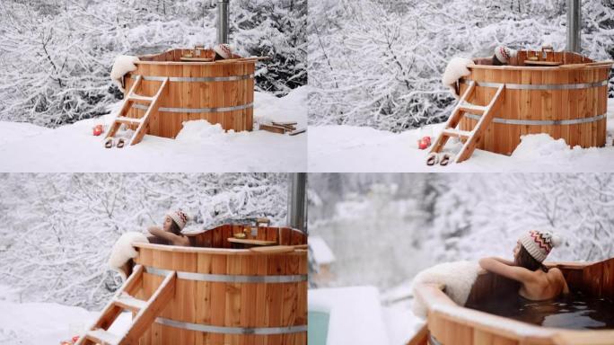 女人在冬天在山上的热桶里放松