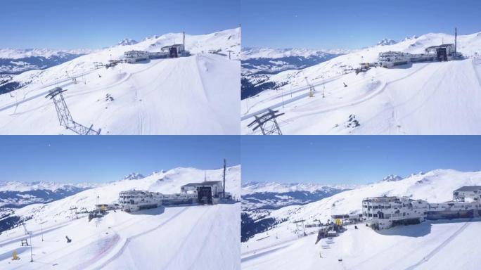 在冬季山区的陡峭滑雪坡上向前飞行。前往带餐厅和酒店的上层缆车站。瑞士Laax