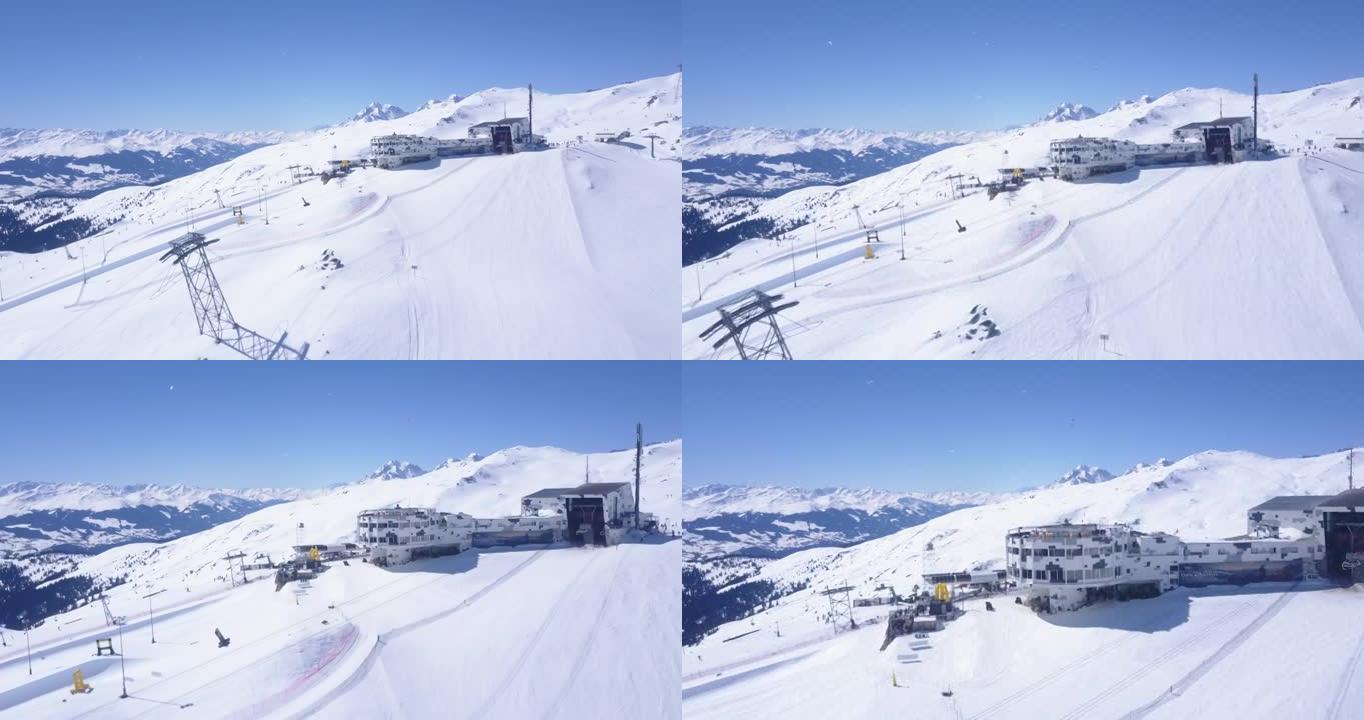 在冬季山区的陡峭滑雪坡上向前飞行。前往带餐厅和酒店的上层缆车站。瑞士Laax