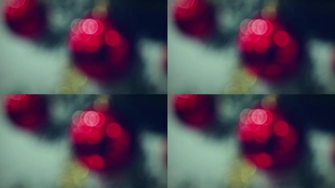 圣诞花环的散焦节日灯在黑暗中发光，红色球反射。圣诞视频背景