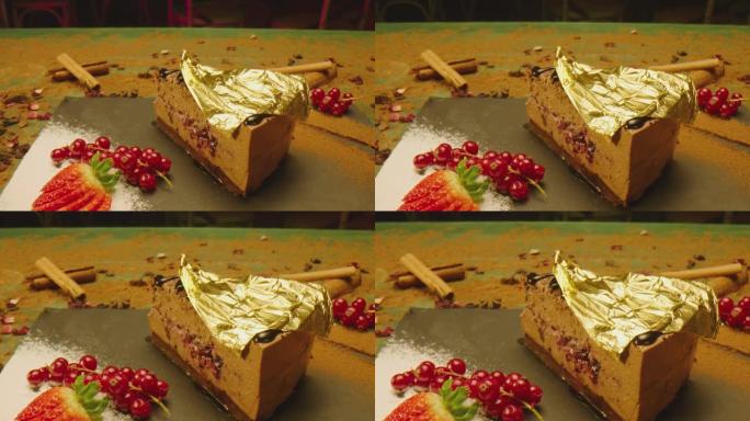 首席炊具把24克拉金片放在布朗尼蛋糕上。美丽昂贵的甜点覆盖着黄金。美味奢华的食物供应方式。漂亮的粉色