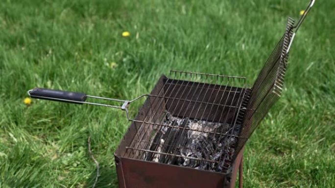 夏日大自然中的火盆。火盆里用来烧烤食物的炭。在火盆上烹饪烧烤。准备烤肉用木炭热。烧烤野餐的概念。