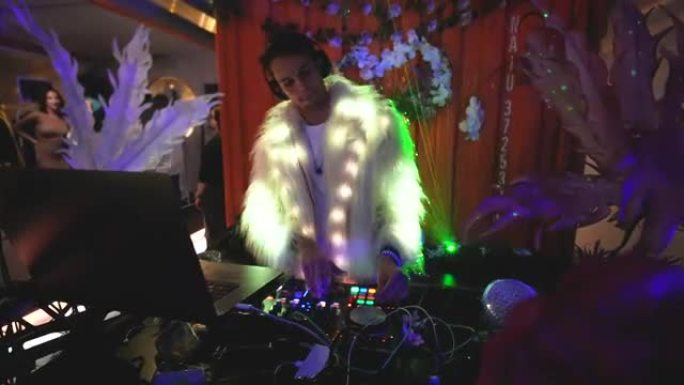 男性dj用遥控音频控制台表演。电子派对夜生活。