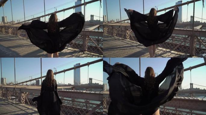 穿着黑色长裙的女人走过纽约布鲁克林大桥