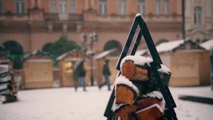 圣诞节市场背景下积雪覆盖的原木的特写镜头
