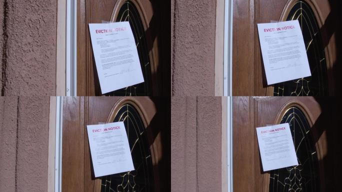 在郊区居民区的出租房屋的木制前门上贴有纸质驱逐通知的照片