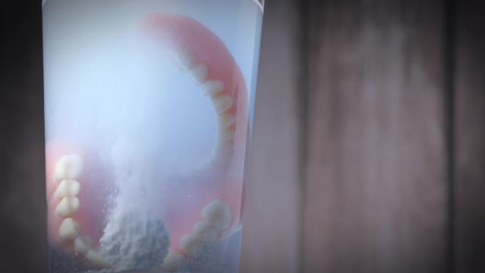 快速溶解在水中的假体牙齿清洁剂片剂的特写镜头。