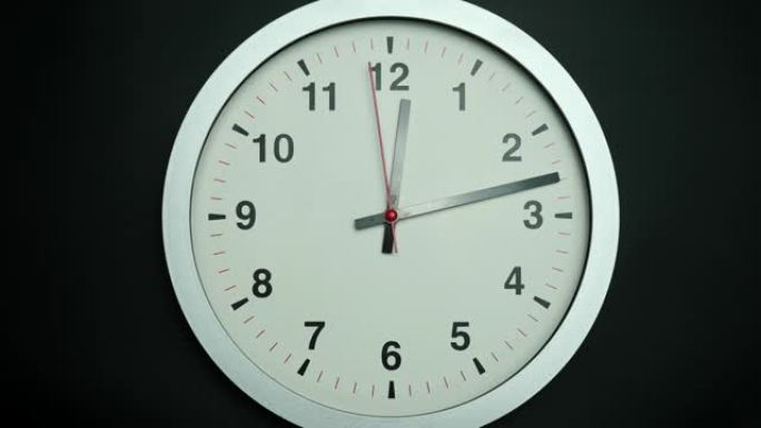 灰色手表隔离在黑色背景、放映时间上午12:13或下午。
