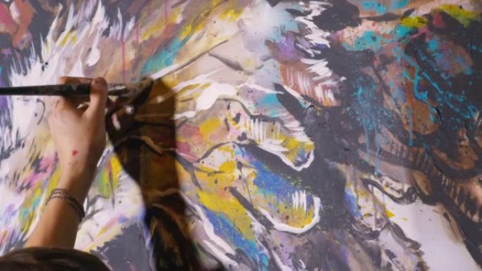 艺术家设计师在墙上画了一只鹰。工匠装饰师用丙烯酸油彩画一幅画。穿着油漆外套的画家