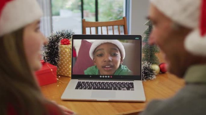 快乐的高加索老人和孙女在圣诞节与男孩进行视频通话