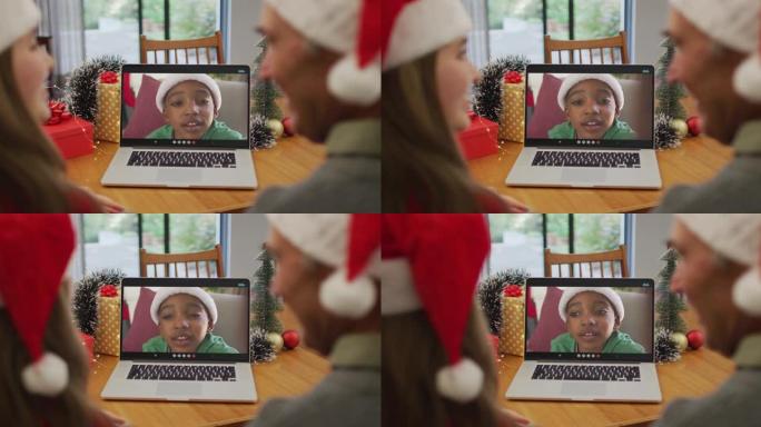 快乐的高加索老人和孙女在圣诞节与男孩进行视频通话