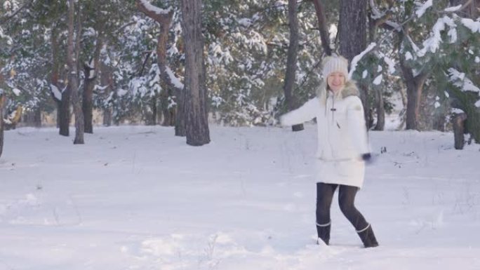 快乐可爱的女孩穿着温暖的冬装跳跃，玩得开心，扔雪。阳光明媚的日子，在新鲜的霜冻空气中享受下雪的冬季乐