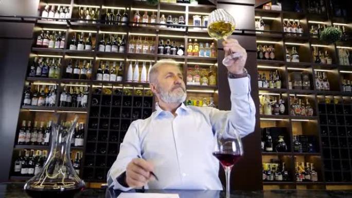 一位老人，大胡子，白发，衣着考究的侍酒师，男性酿酒师，品尝香气并检查倒入透明玻璃杯中的葡萄酒的质量。